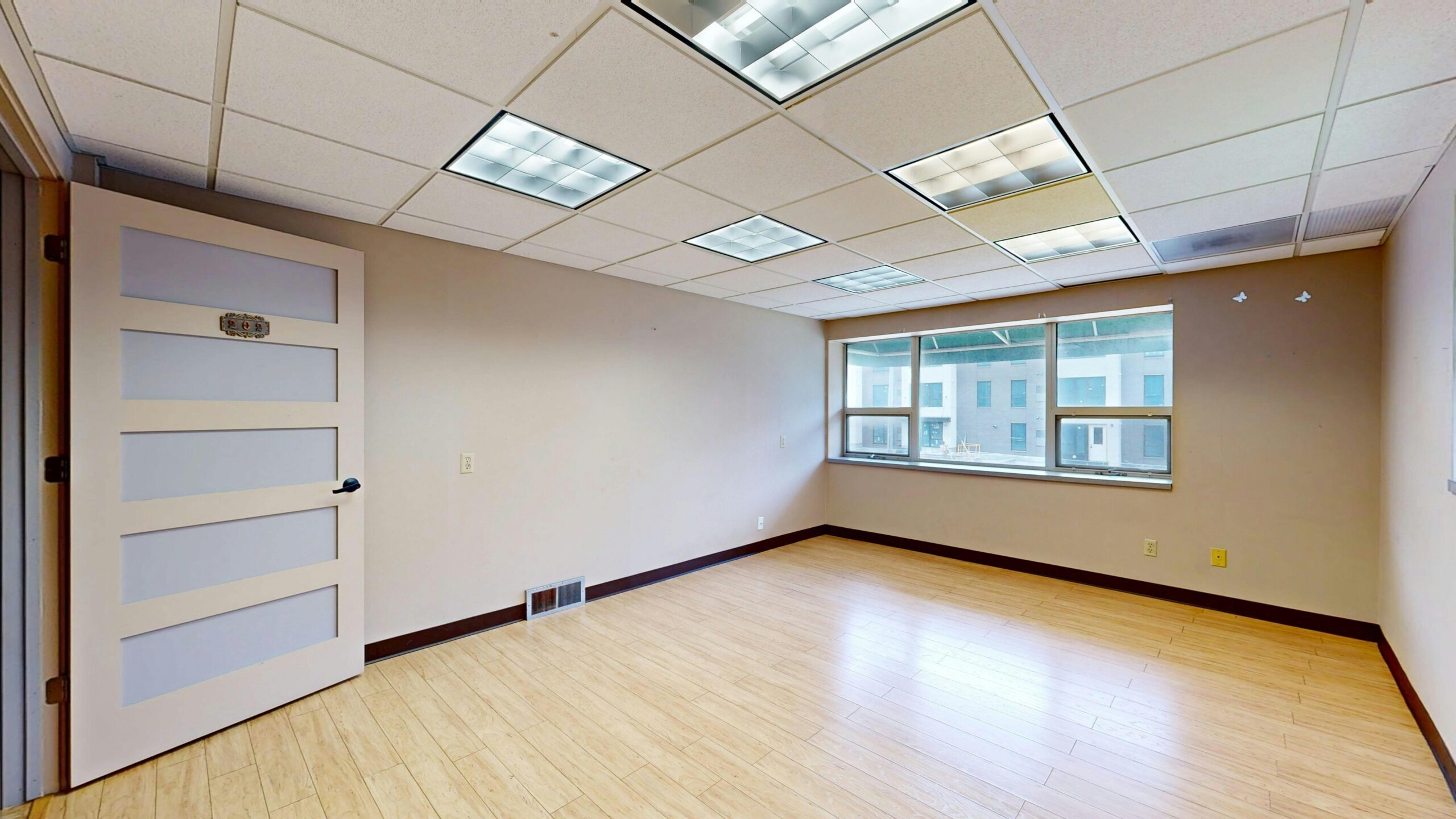 Vacant modern office space with large windows and natural light.